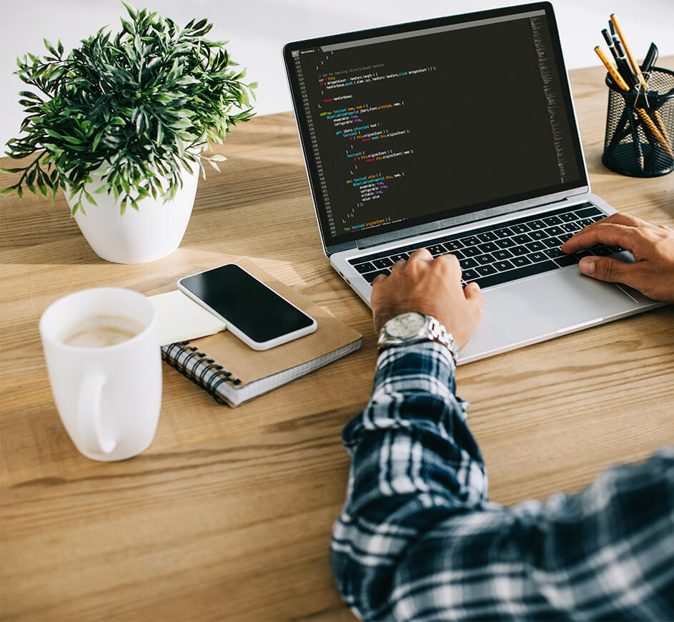 A developer's workspace with a laptop showing JavaScript code, a coffee cup, and a plant, representing mhsadik's clean coding environment.